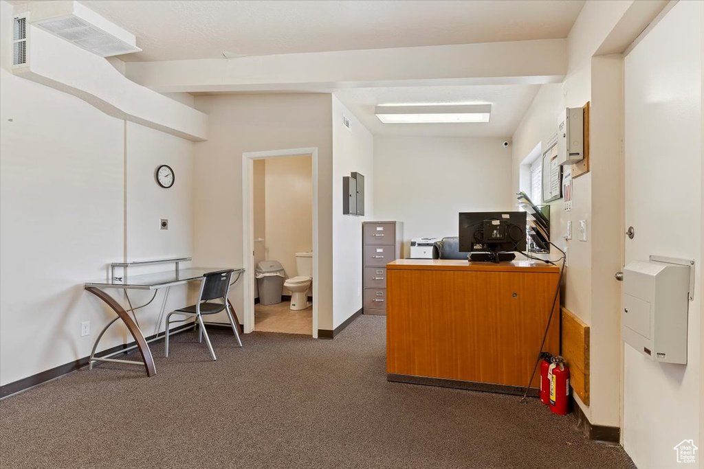 Home office featuring dark colored carpet