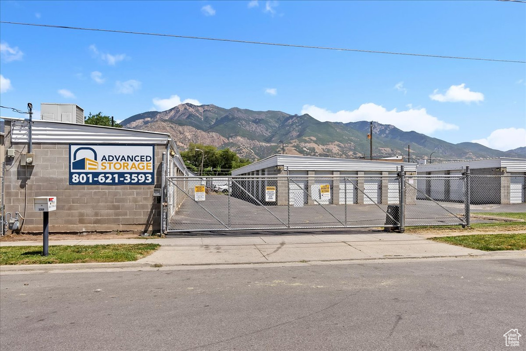 View of asphalt street with a gate, a mountain view, and sidewalks