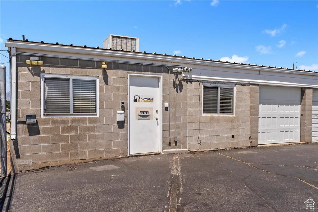 View of exterior entry featuring concrete block siding and a metal roof