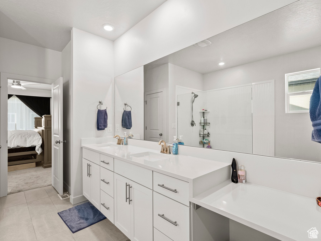 Ensuite bathroom featuring double vanity, ceiling fan, tile patterned flooring, recessed lighting, and a shower