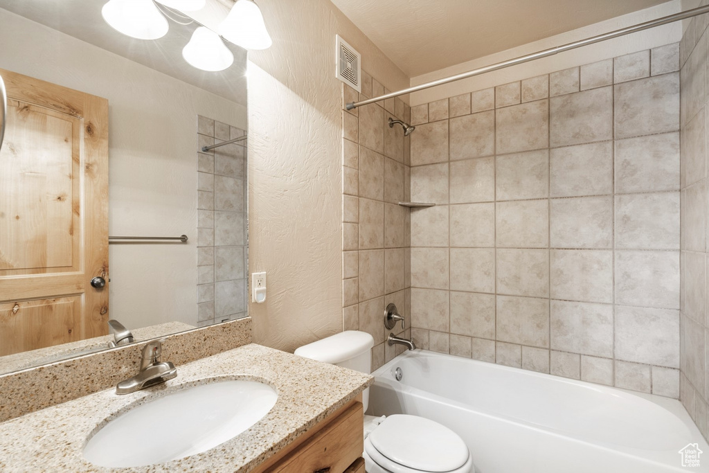 Bathroom with vanity,  shower combination, and a textured wall