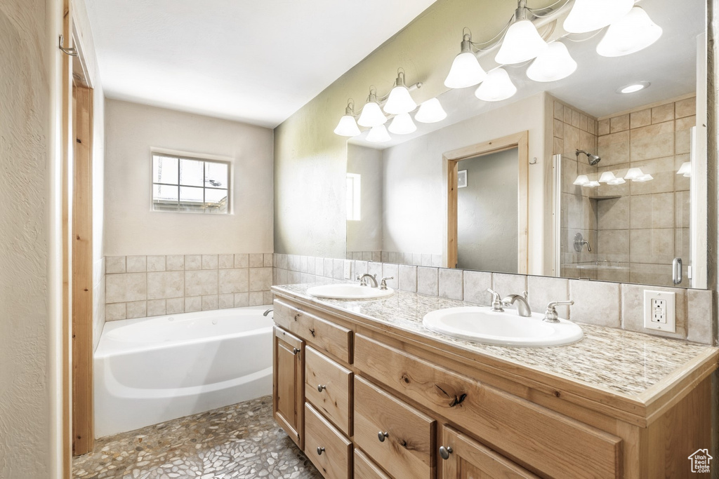 Bathroom featuring a garden tub, double vanity, a stall shower, and tile patterned floors