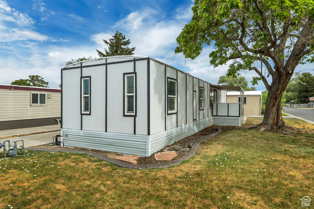 View of property exterior with a yard
