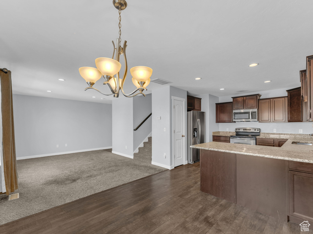 Kitchen featuring stainless steel appliances, recessed lighting, dark wood-style floors, dark brown cabinetry, and open floor plan