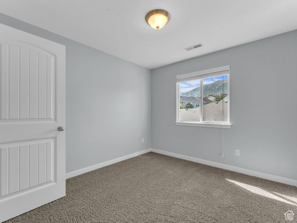 Carpeted empty room with baseboards