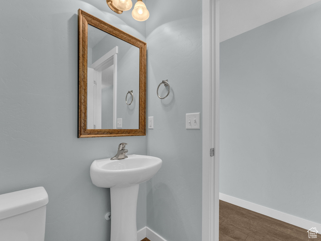 Half bath featuring wood finished floors and toilet