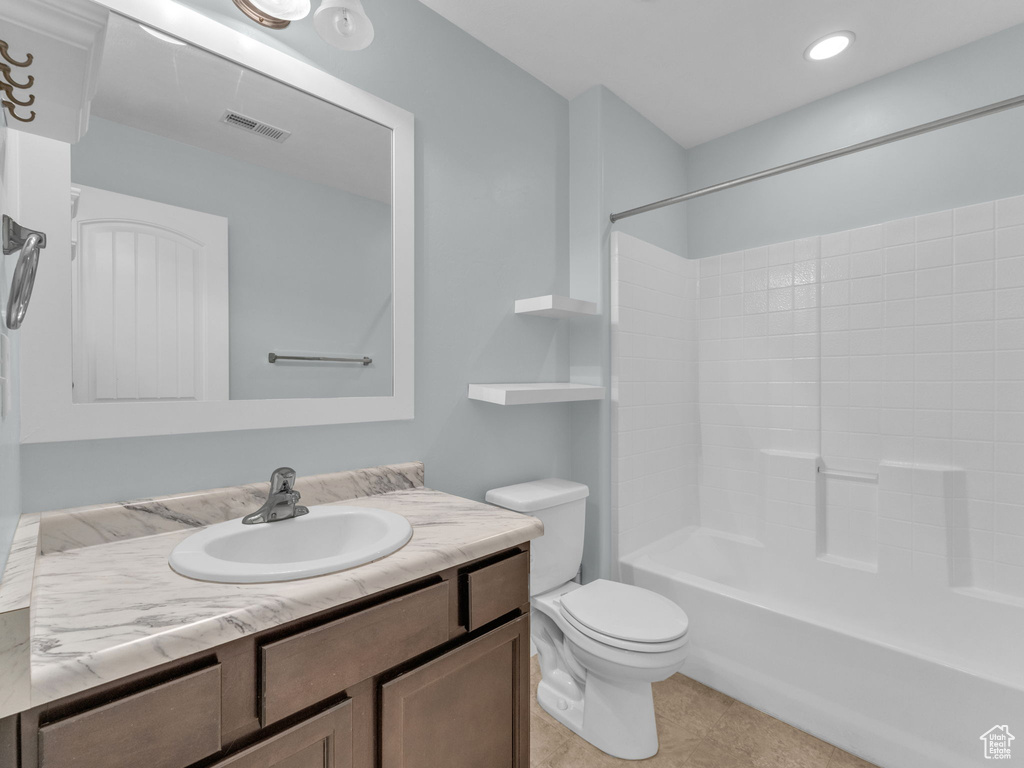 Bathroom with vanity, shower / bath combination, and tile patterned flooring