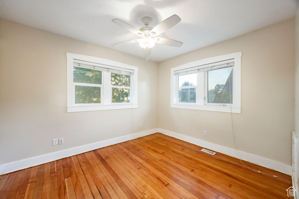Empty room featuring plenty of natural light, light wood-style flooring, and ceiling fan