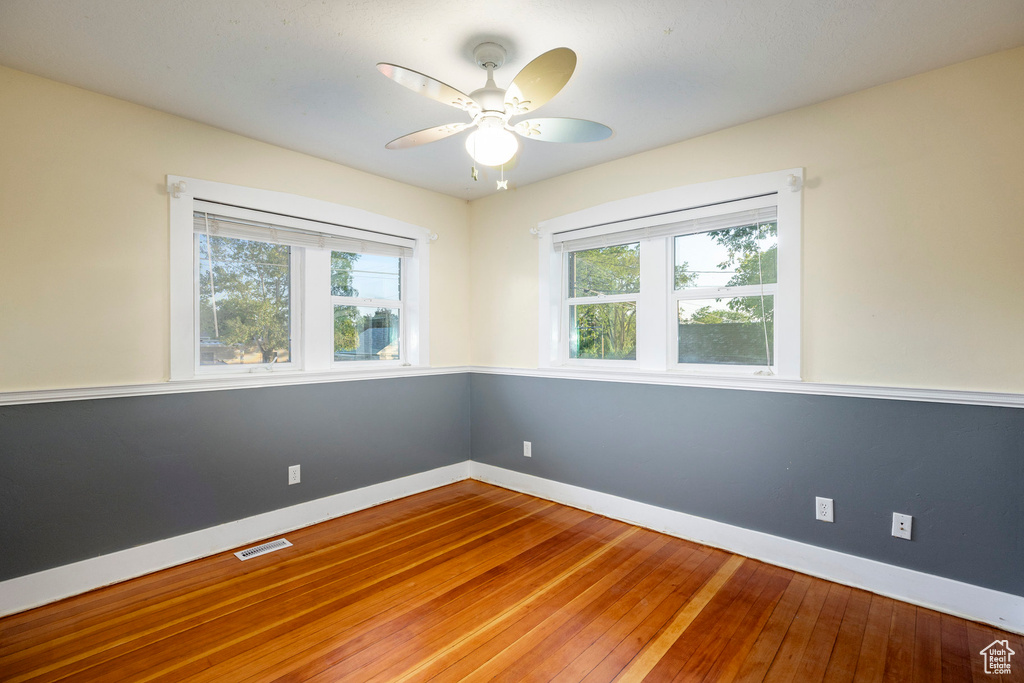 Empty room with hardwood / wood-style flooring and ceiling fan