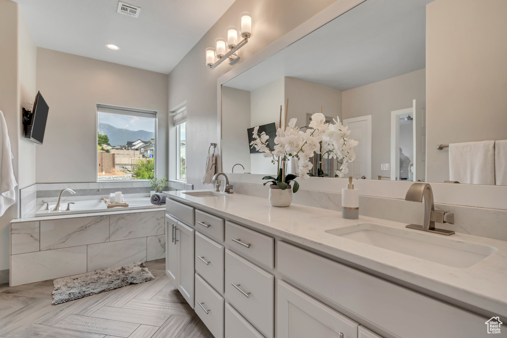 Full bathroom with double vanity and a bath