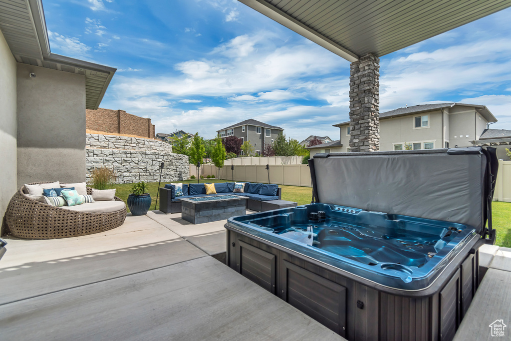 View of patio with a hot tub, a residential view, and an outdoor living space with a fire pit