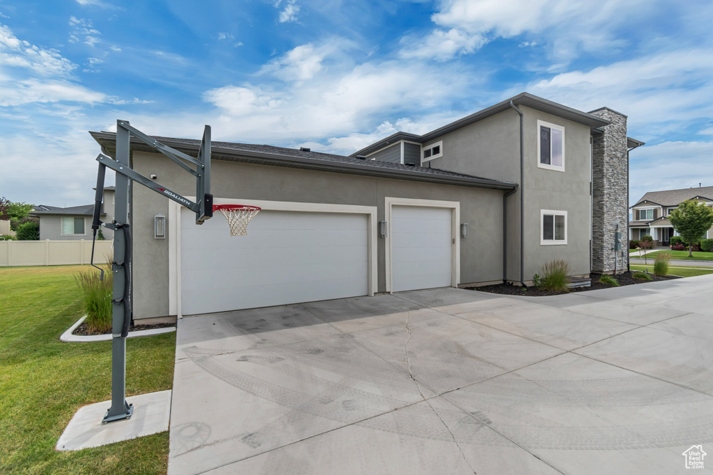 View of property exterior featuring a garage, driveway, and stucco siding