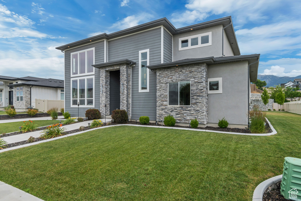 View of front of home featuring stone siding and stucco siding