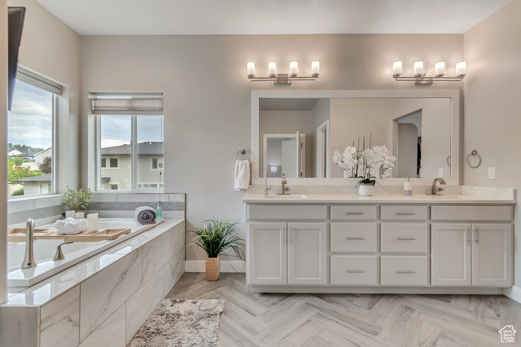 Full bath featuring double vanity and a bath