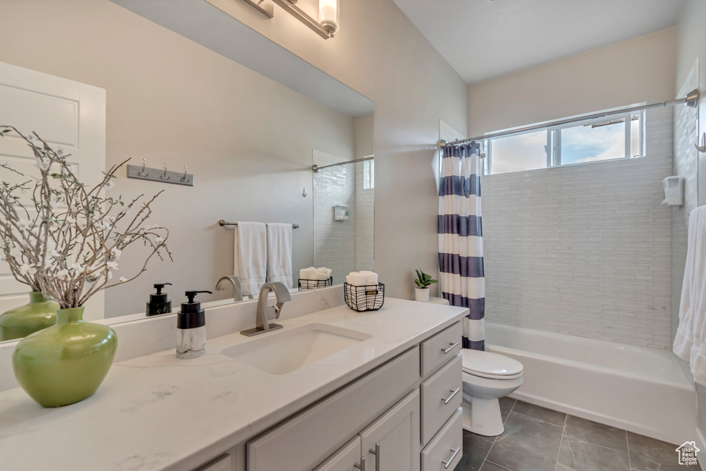 Full bathroom featuring vanity, shower / tub combo with curtain, and tile patterned flooring