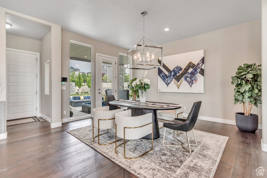 Dining space with a chandelier, dark wood-style floors, and recessed lighting