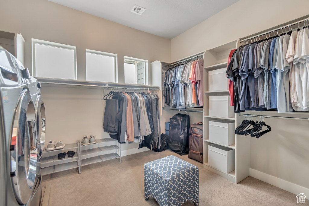 Spacious closet with washing machine and dryer and carpet