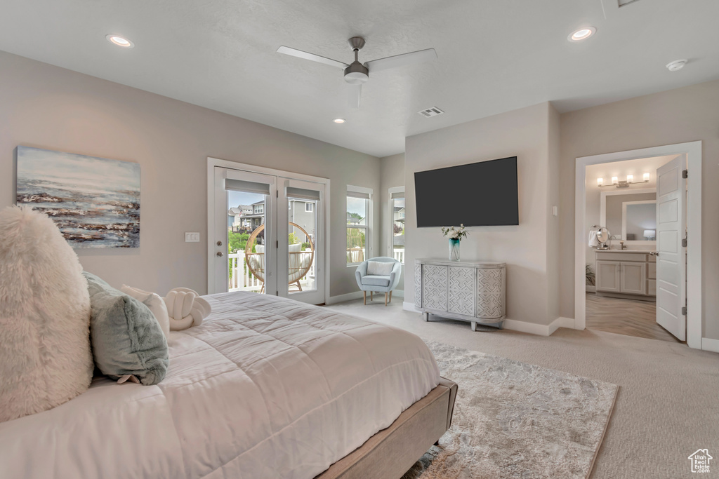 Bedroom featuring access to exterior, light colored carpet, recessed lighting, ensuite bathroom, and french doors