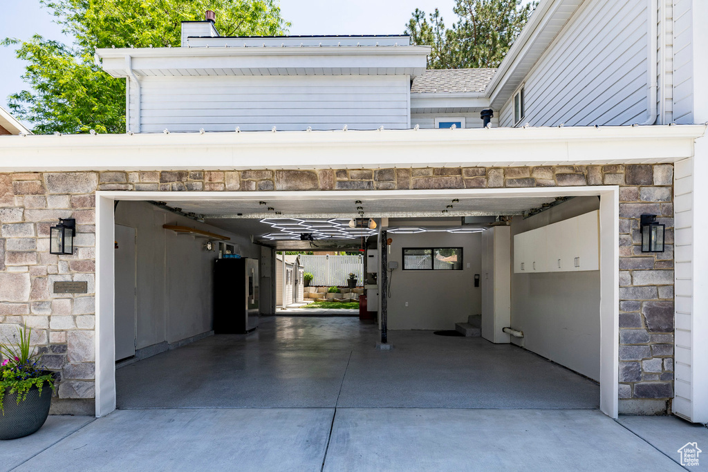 Garage with freestanding refrigerator and driveway