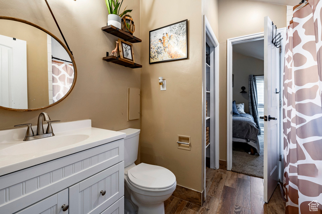 Bathroom with wood finished floors, vanity, connected bathroom, and a shower with curtain