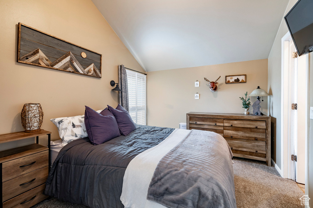 Carpeted bedroom featuring vaulted ceiling