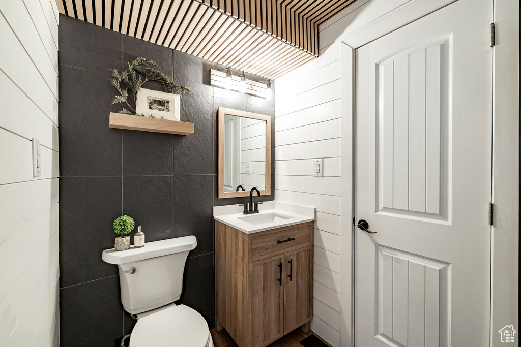 Bathroom featuring vanity and tile walls