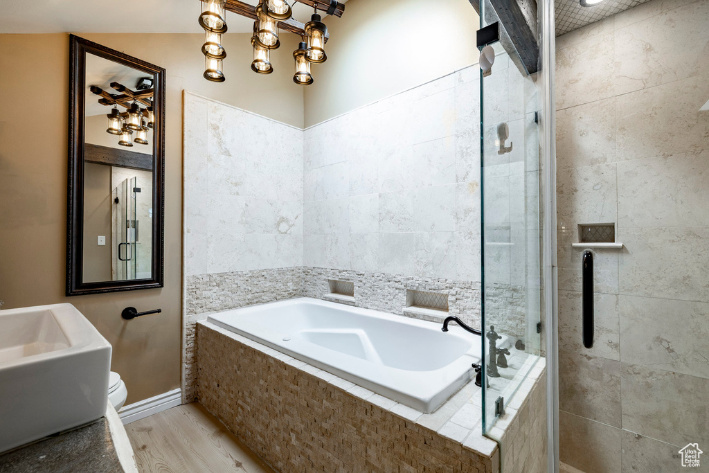 Bathroom featuring a bath, a shower stall, and wood finished floors