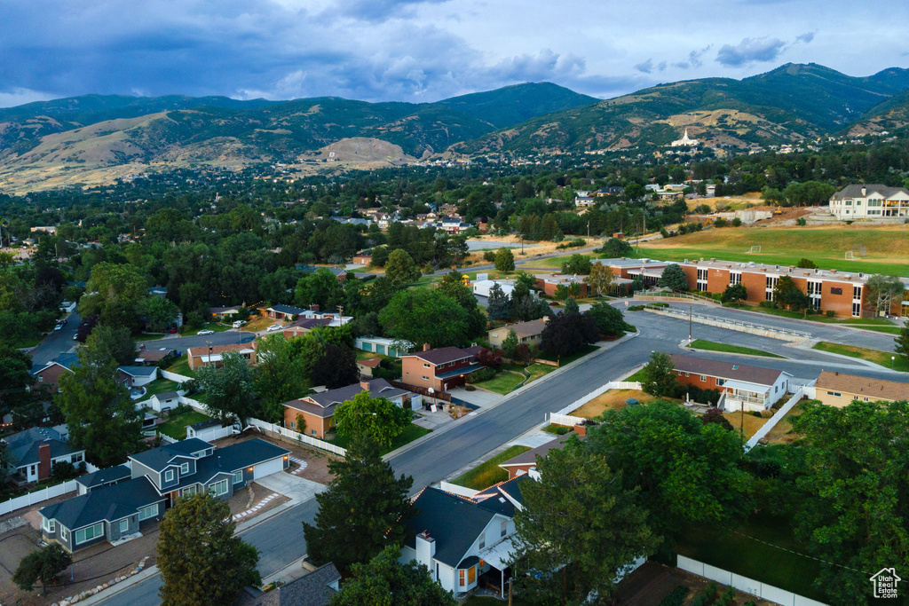 Aerial view of property's location featuring a mountain backdrop and nearby suburban area