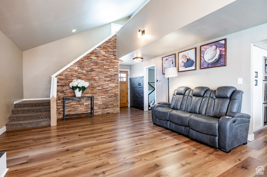 Living room featuring a high ceiling, wood finished floors, and stairs