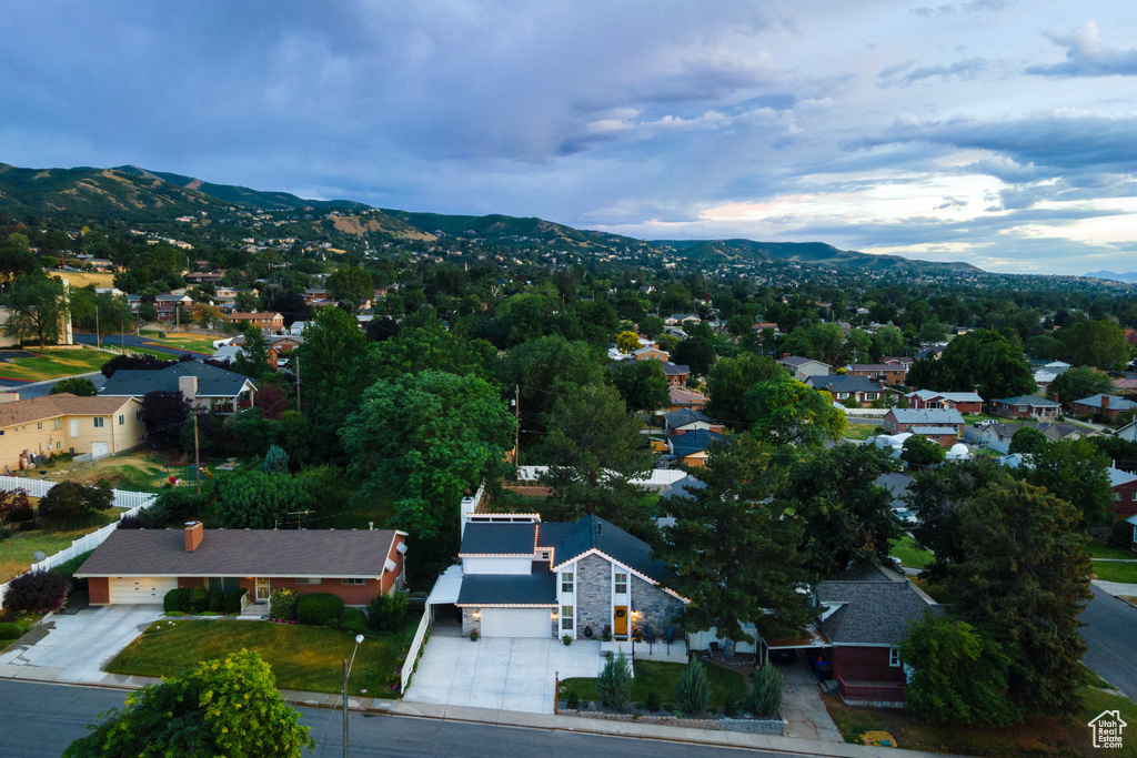 Aerial view of property and surrounding area featuring a mountain backdrop and nearby suburban area
