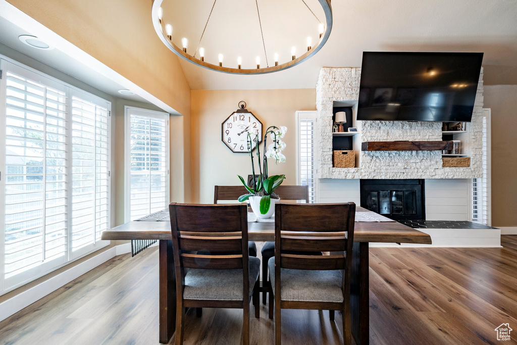 Dining space with wood finished floors, plenty of natural light, and a fireplace