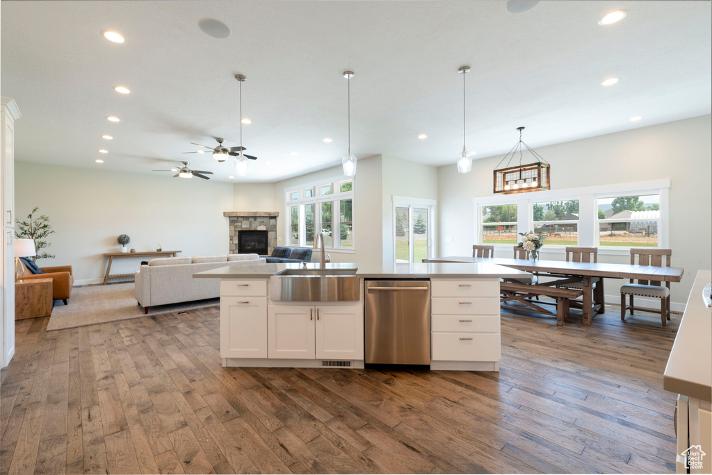 Kitchen with dishwasher, recessed lighting, a fireplace, plenty of natural light, and dark wood-type flooring