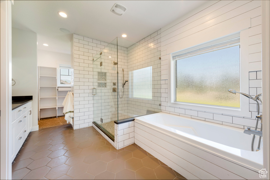 Bathroom with a shower stall, a garden tub, tile patterned flooring, recessed lighting, and vanity