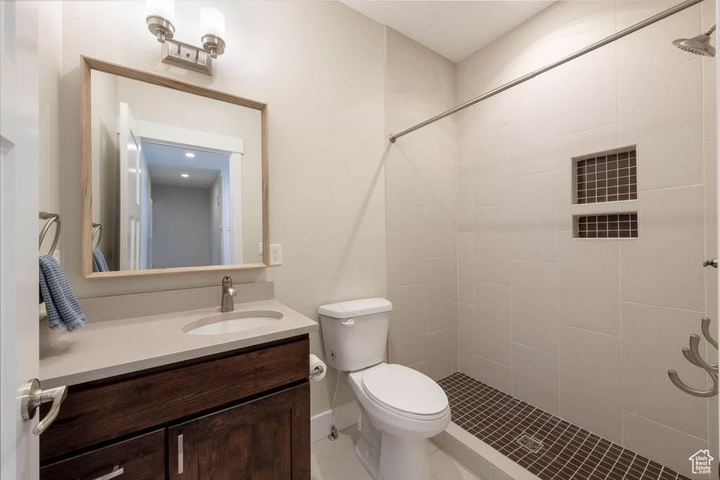 Bathroom featuring a tile shower and vanity