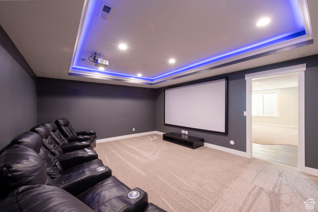Home theater with a tray ceiling, carpet, and recessed lighting