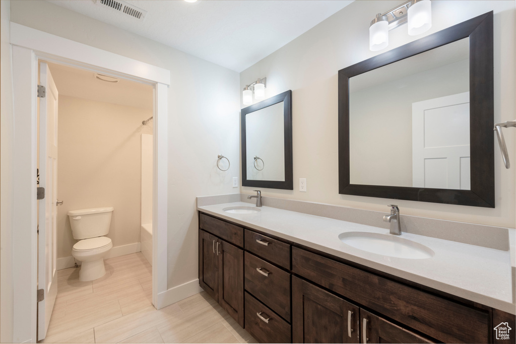 Bathroom featuring double vanity and bathing tub / shower combination