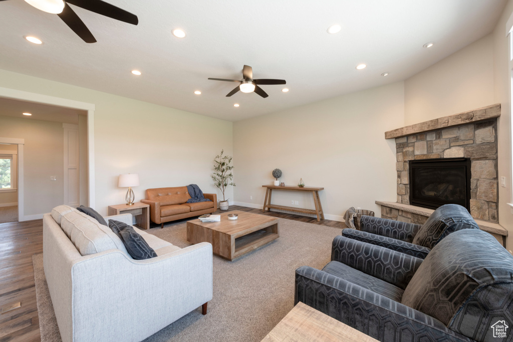 Living area featuring ceiling fan, recessed lighting, a stone fireplace, and wood finished floors