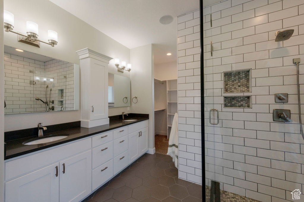 Full bathroom featuring a shower stall, tile patterned floors, double vanity, and recessed lighting