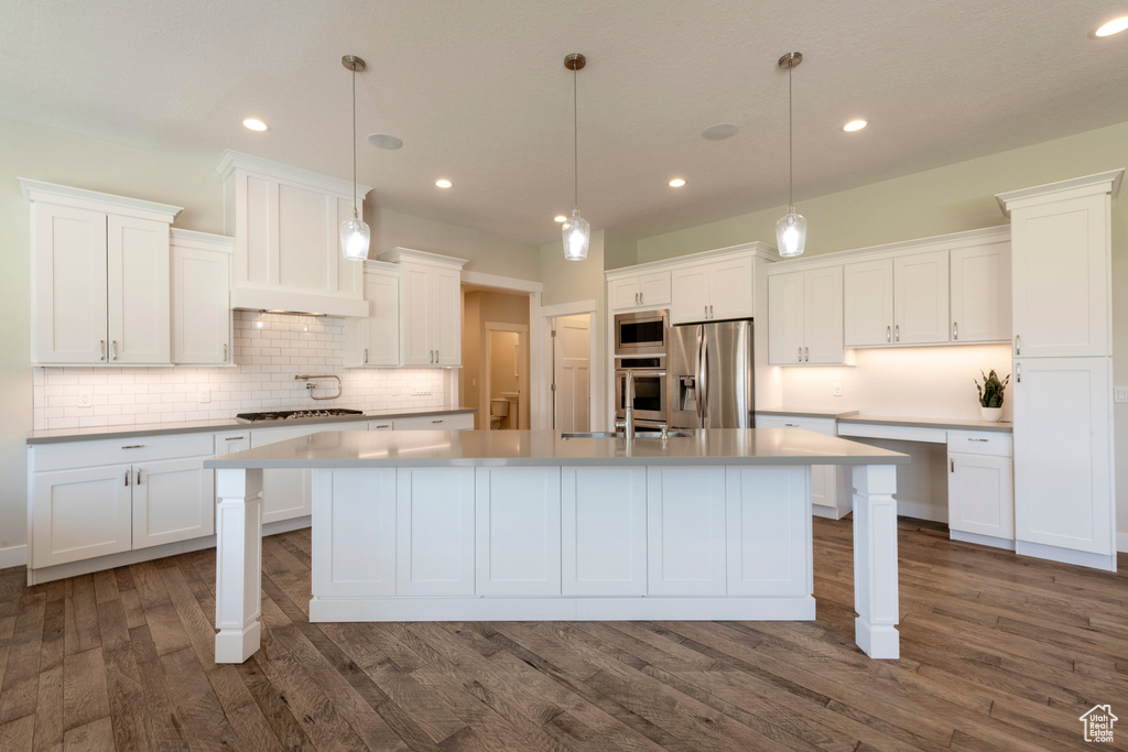 Kitchen featuring appliances with stainless steel finishes, white cabinets, decorative backsplash, and recessed lighting