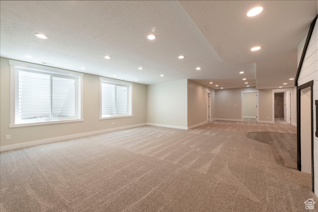 Unfurnished living room with light carpet and recessed lighting