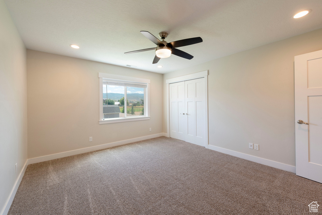 Unfurnished bedroom featuring carpet floors, a ceiling fan, recessed lighting, and a closet