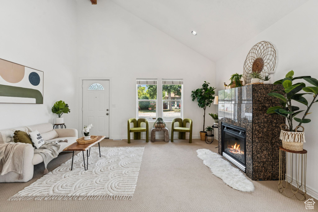 Living area featuring high vaulted ceiling, carpet floors, and a high end fireplace