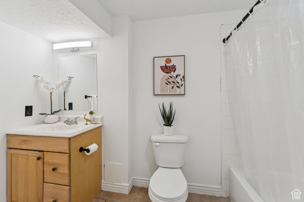 Bathroom featuring vanity, tile patterned floors, and shower / bath combination with curtain