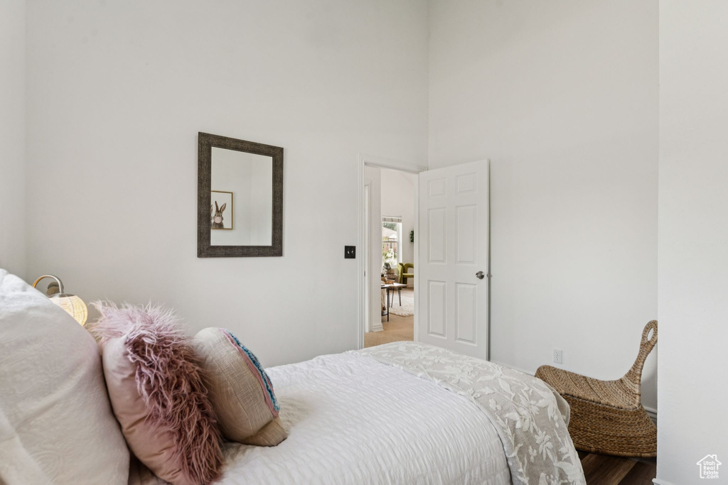Bedroom with wood finished floors and a towering ceiling