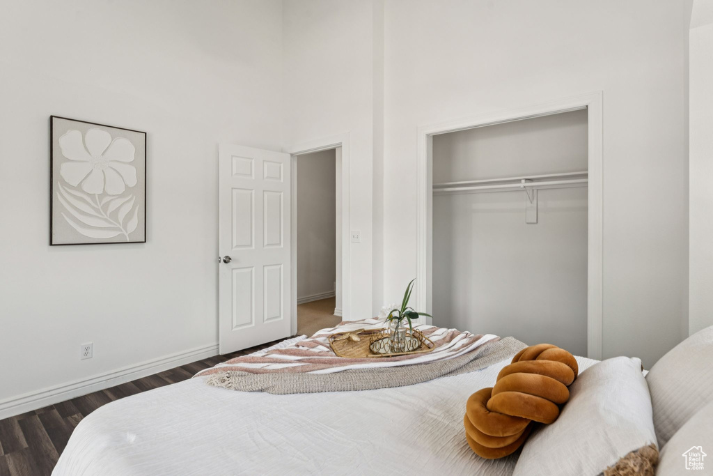 Bedroom with dark wood-style floors and a closet