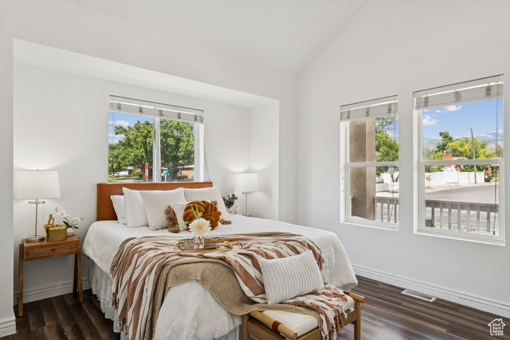 Bedroom featuring lofted ceiling and dark wood-style floors