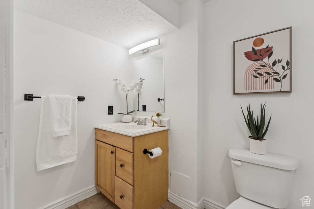 Half bath with vanity and a textured ceiling