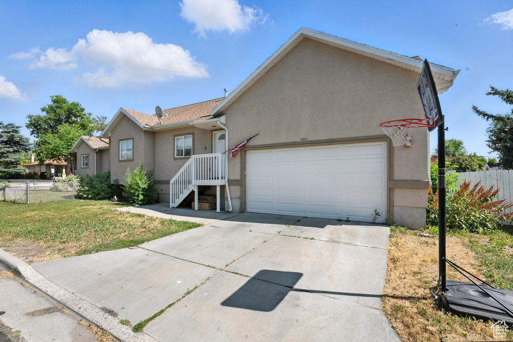 Ranch-style house with stucco siding, a garage, and concrete driveway