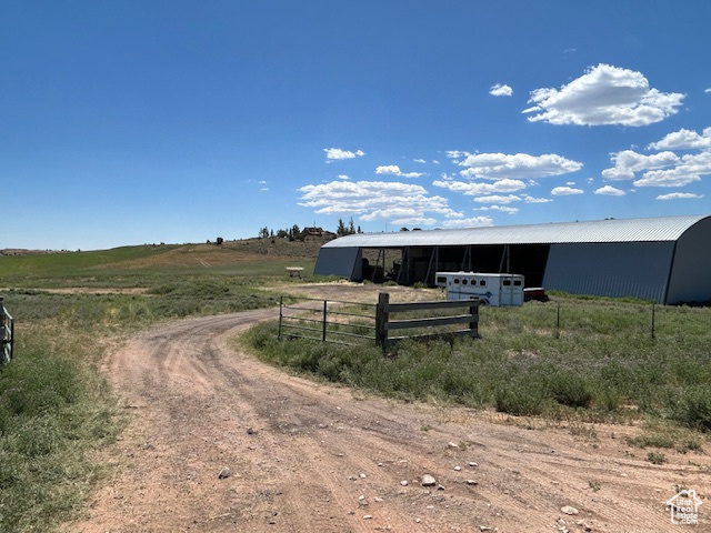 View of dirt / gravel road featuring an outbuilding and a rural view