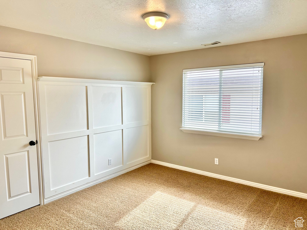 Unfurnished bedroom with carpet and a textured ceiling